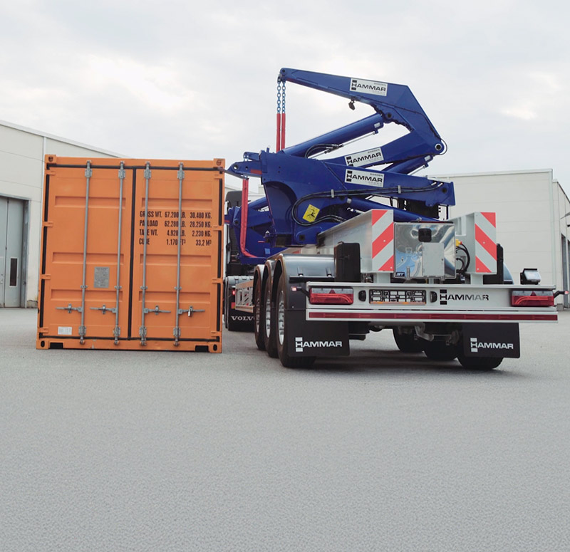 Hammar 195 sideloader approaching an orange container on stable ground