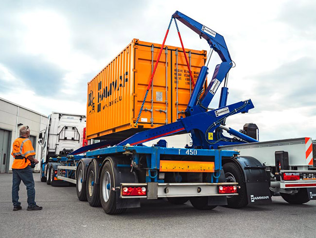 A Hammar 195 safely lifting an orange container from another truck chassis | Southwest Level Lift